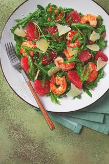 Fresh shrimp salad with arugula, grapefruit, and parmesan served in a bowl