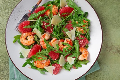 Fresh shrimp salad with arugula, grapefruit, and parmesan served in a bowl