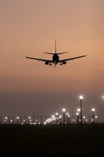 Boeing 737 jet passenger aircraft of Ryanair airlines landing over runway lights at sunset, London