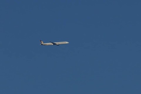 Boeing 777 jet passenger aircraft of Singapore airlines in flight in a blue sky, England, United
