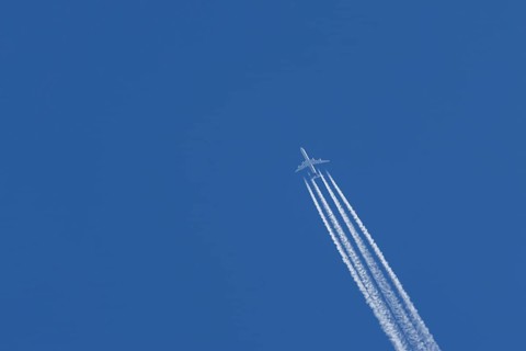 Airbus A340-300 jet aircraft of Lufthansa airlines in flight in a blue sky with vapour trails or