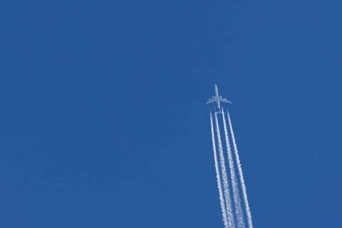 Airbus A340-300 jet aircraft of Lufthansa airlines in flight in a blue sky with vapour trails or