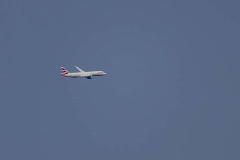 Boeing 787-9 Dreamliner jet passenger aircraft of British Airways airlines in flight in a blue sky,