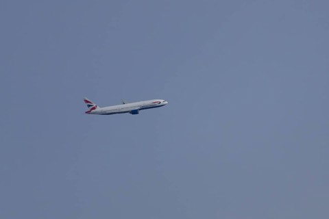 Boeing 787-9 Dreamliner jet passenger aircraft of British Airways airlines in flight in a blue sky,