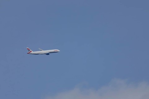 Boeing 787-9 Dreamliner jet passenger aircraft of British Airways airlines in flight in a blue sky,