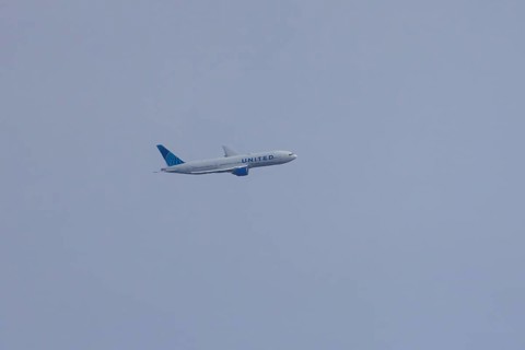Jet passenger aircraft of United airways in flight in a blue sky, London, England, United Kingdom