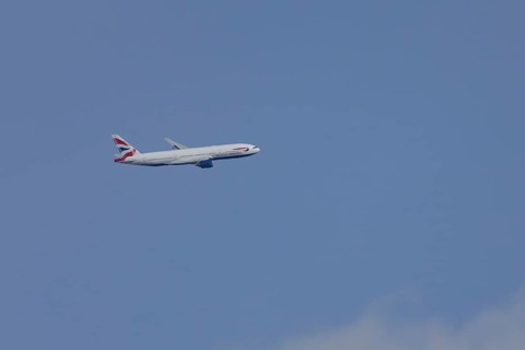 Boeing 787-9 Dreamliner jet passenger aircraft of British Airways airlines in flight in a blue sky,
