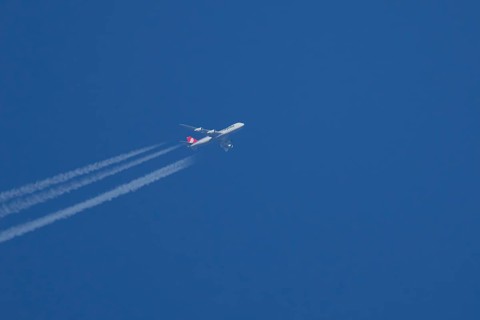 Boeing 747 Jumbo jet cargo aircraft of Cargolux airlines in flight in a blue sky with vapour trails