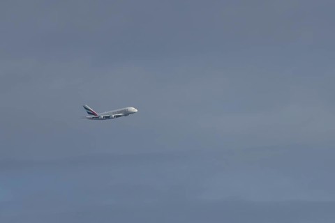Airbus A380 jet passenger aircraft of Emirates airlines flying in a blue sky, England, United