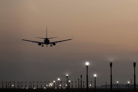 Boeing 737 jet passenger aircraft of Ryanair airlines landing over runway lights at sunset, London
