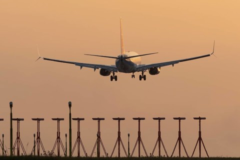 Boeing 737 jet passenger aircraft of Ryanair airlines landing over runway lights at sunset, London