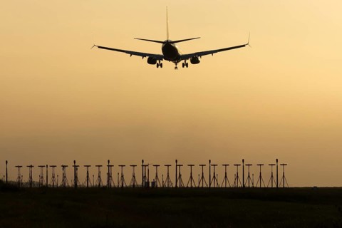 Boeing 737 jet passenger aircraft of Ryanair airlines landing over runway lights at sunset, London