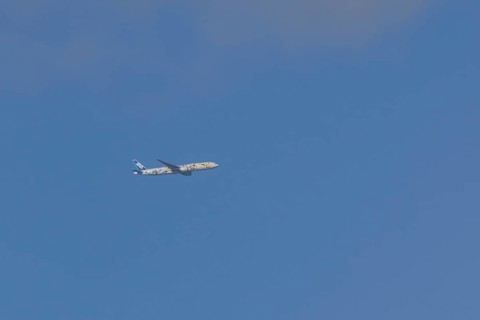 Jet passenger aircraft of ANA airways in flight in a blue sky, London, England, United Kingdom