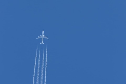 Airbus A340-300 jet aircraft of Lufthansa airlines in flight in a blue sky with vapour trails or