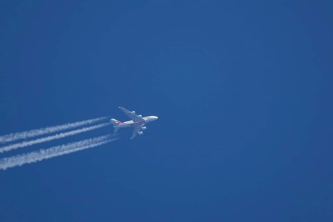 Airbus A380 jet passenger aircraft of Emirates airlines flying with vapour trails or contrails