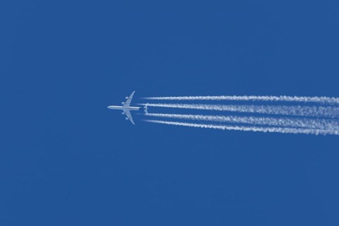 Airbus A340-300 jet aircraft of Lufthansa airlines in flight in a blue sky with vapour trails or