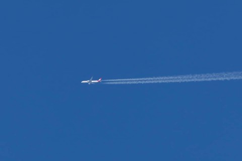 Airbus passenger jet aircraft of Austrian Airlines flying with a vapour trial or contrail behind in