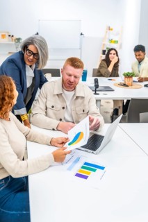 Business professionals collaborating and discussing marketing data with charts and graphs on