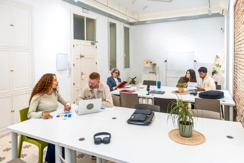 Group of diverse business professionals discussing ideas, analyzing documents, and working on