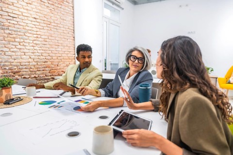 Diverse business professionals collaborating in a modern office. Analyzing data and discussing