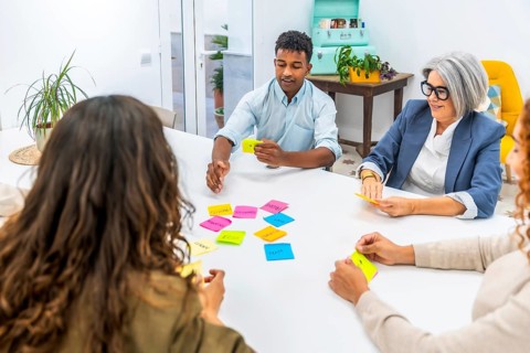 Diverse business team collaborating and exchanging ideas in a creative meeting, using colorful
