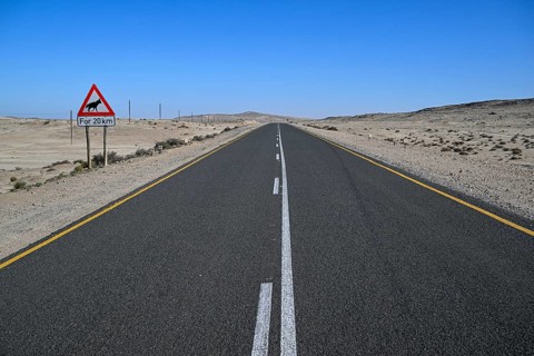 Sign warning of brown hyenas or beach wolves (Parahyaena brunnea), near Lüderitz, Karas Region,