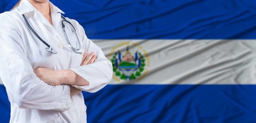 Doctor with crossed arms on El Salvador flag. El Salvador health and care concept. Female doctor on