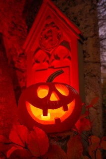 Halloween pumpkin with candlelight in the cemetery, illuminated red and spooky