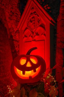Halloween pumpkin with candlelight in the cemetery, illuminated red and spooky