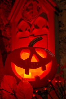 Halloween pumpkin with candlelight in the cemetery, illuminated red and spooky