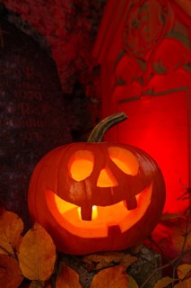 Halloween pumpkin with candlelight in the cemetery, illuminated red and spooky