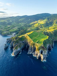 Cape Furado, Rocky Cliffs, Hills, Green Lush Fields, Pasturelands and Atlantic Ocean at Sunrise.