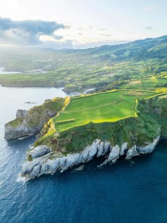 Cape Furado, Cliffs, Hills, Green Lush Fields, Pasturelands and Atlantic Ocean on Sunny Morning.