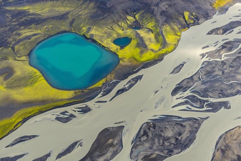 Turquoise crater lake next to intertwined glacial river, Icelandic Highlands, Iceland