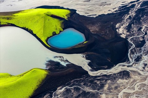 Turquoise-coloured crater lake with moss-covered crater rims in the Icelandic highlands, surrounded