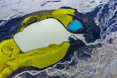 Turquoise-coloured crater lake with moss-covered crater rims in the Icelandic highlands, surrounded