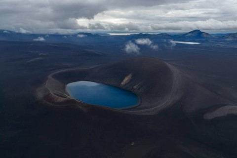 Blue crater lake in black sand desert, Icelandic Highlands, Iceland