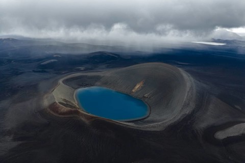 Blue crater lake in black sand desert, Icelandic Highlands, Iceland