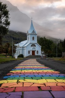 Church with rainbow pedestrian path in the town of Seyðisfjörður, East Iceland, Iceland