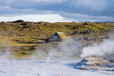 Steaming springs and traditional house at the Hveravellir geothermal area, Icelandic Highlands,