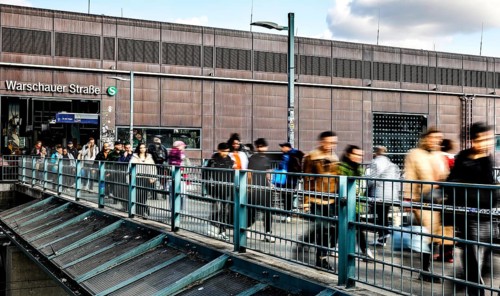 People walking across a bridge at Warschauer Straße station, Berlin, 02 October 2025, Berlin,