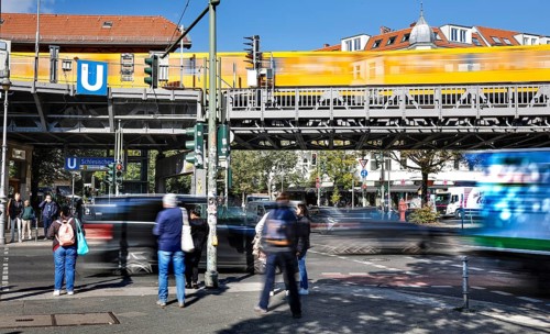 Street scene at Schlesisches Tor underground station, yellow underground train on elevated railway,