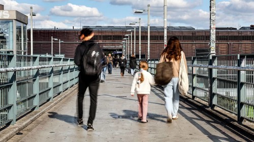People walking across a bridge at Warschauer Straße station, Berlin, 02 October 2025, Berlin,