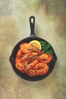 Fried white-footed shrimp, tiger shrimp baths, in a cast-iron skillet, with lemon and herbs, no