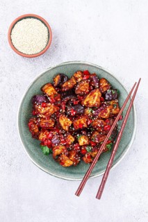 Fried eggplant, Chinese style, in sweet and sour sauce, with pepper and sesame seeds, in a green