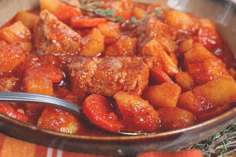 Meat goulash with potatoes and carrots, sweet peppers, in a saucepan, top view, traditional