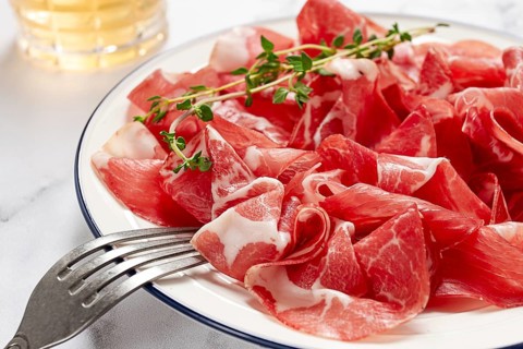 Plate with sliced cured meat, pork neck, prosciutto coppa, Italian delicacy