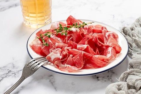 Plate with sliced cured meat, pork neck, prosciutto coppa, Italian delicacy