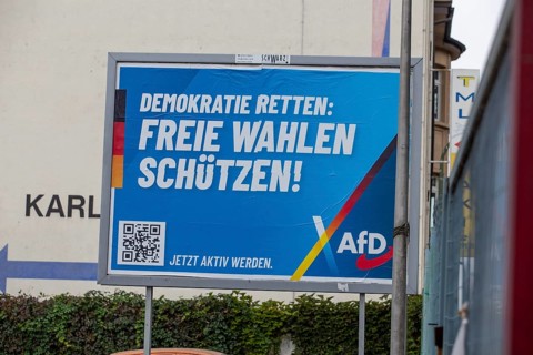 AfD poster in Ludwigshafen with the text DEMOKRATIE RETTEN, FREIE WAHLEN SCHÜTZEN. The city's