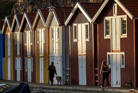 Strollers in front of colourful boathouses in the harbour of Smögen, Smögenbryggan, Västra
